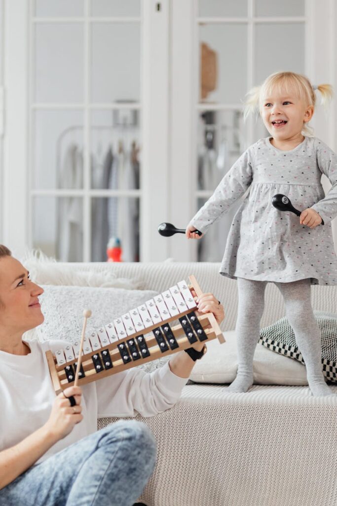 A mother and daughter bond through music at home, playing joyful melodies.