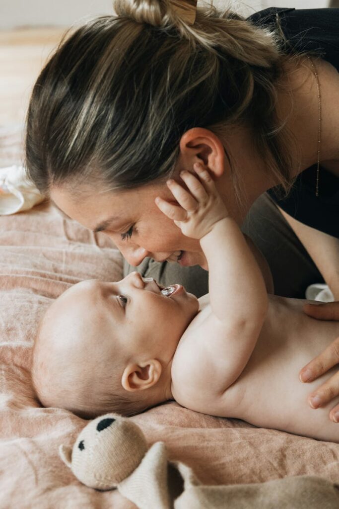 A mother lovingly interacts with her baby, capturing an intimate bonding moment.