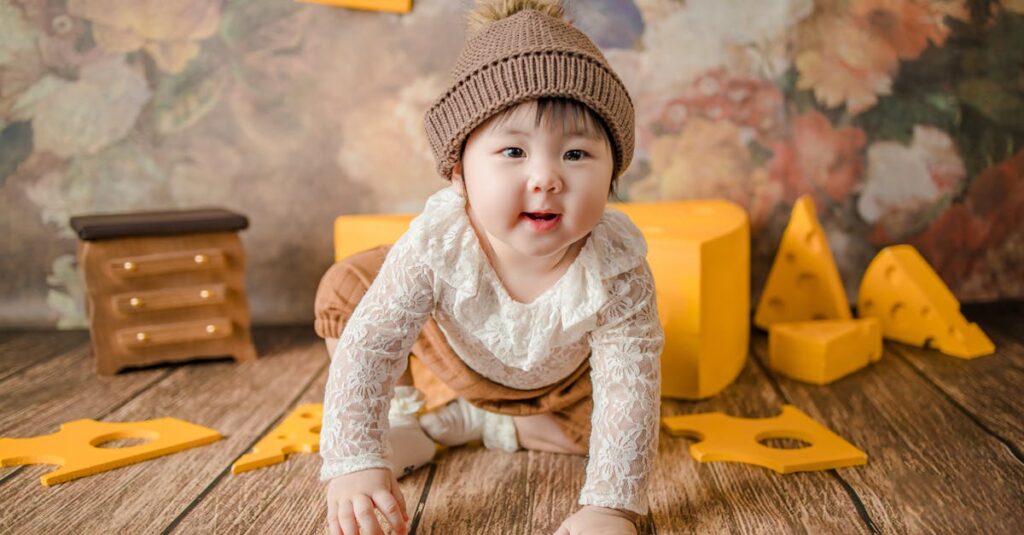 Cute baby in a knit hat crawling on a decorated wooden floor with a warm smile.