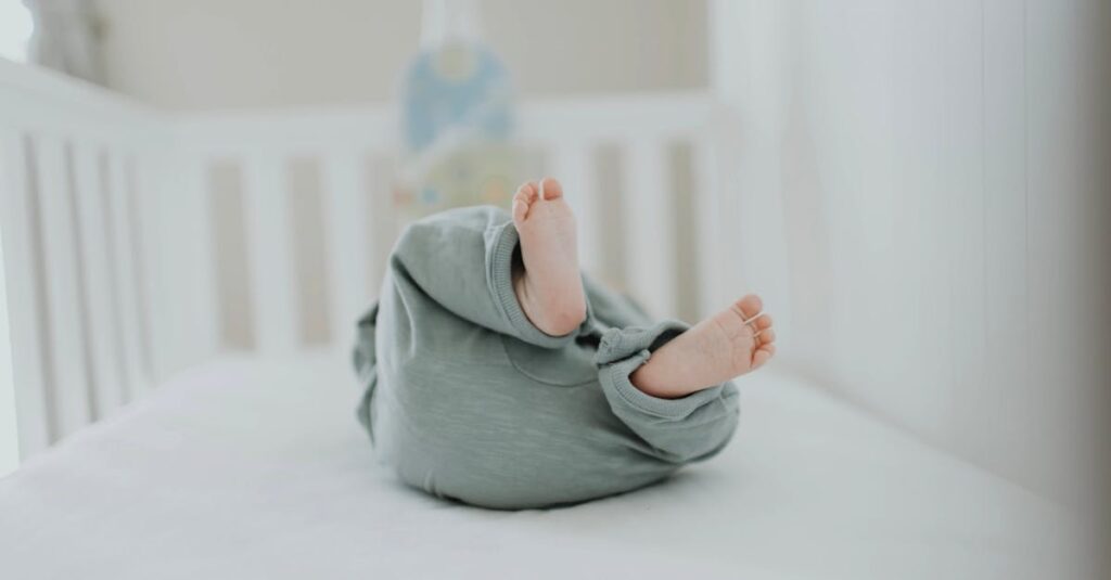 Cute baby feet in pajamas on a soft white crib. Perfect for children's room decor.