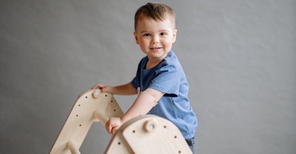 Young child in a blue shirt climbing a wooden ladder toy in a playroom setting.