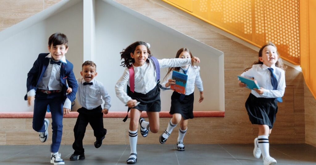 Happy school children in uniforms running energetically indoors, expressing excitement.